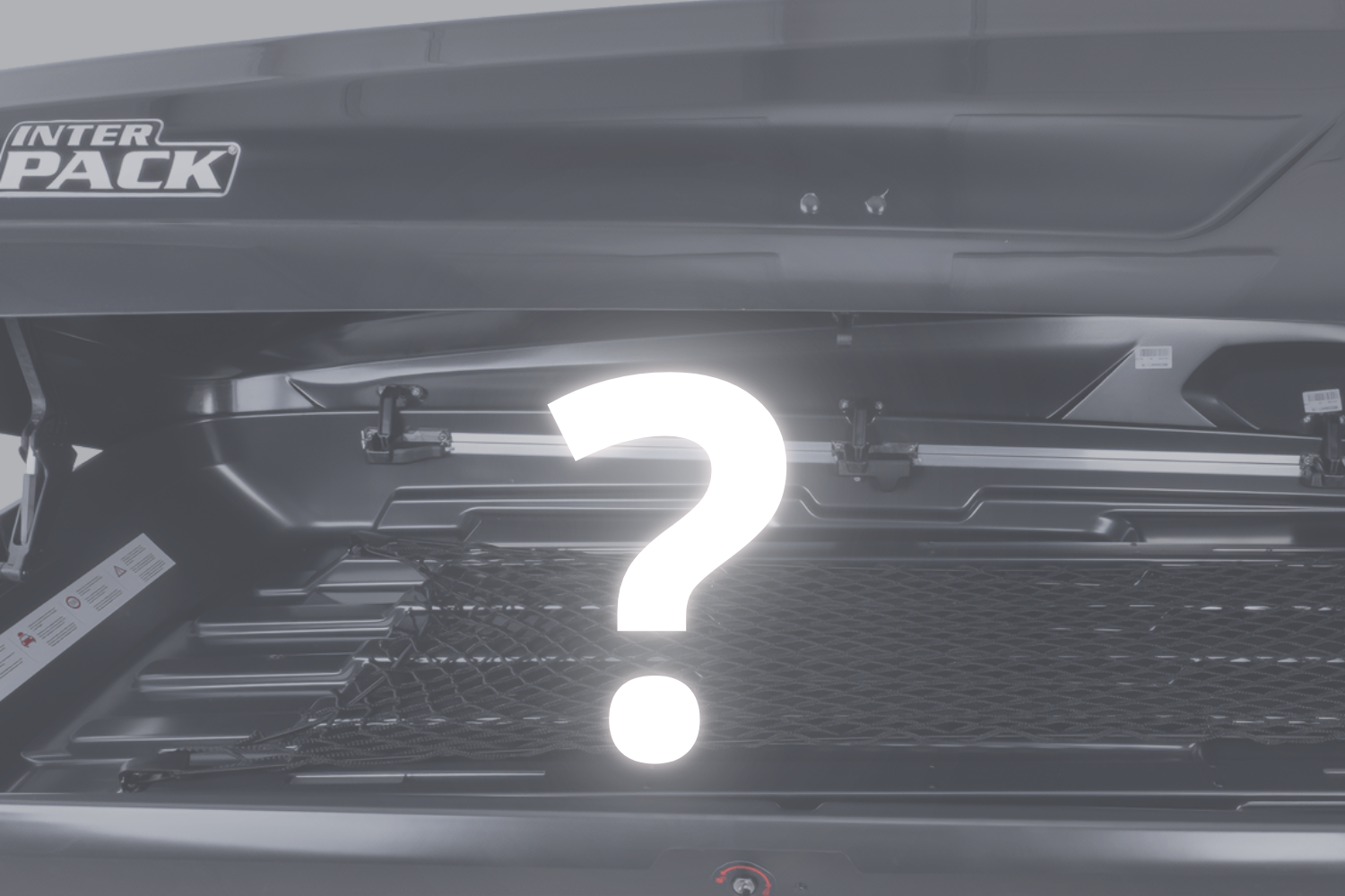 Nahaufnahme einer schwarzen Dachbox mit dem Inter-Pack-Logo. Die Box ist geöffnet und innen leer. In der Mitte der Grafik befindet sich ein weißes Fragezeichen.