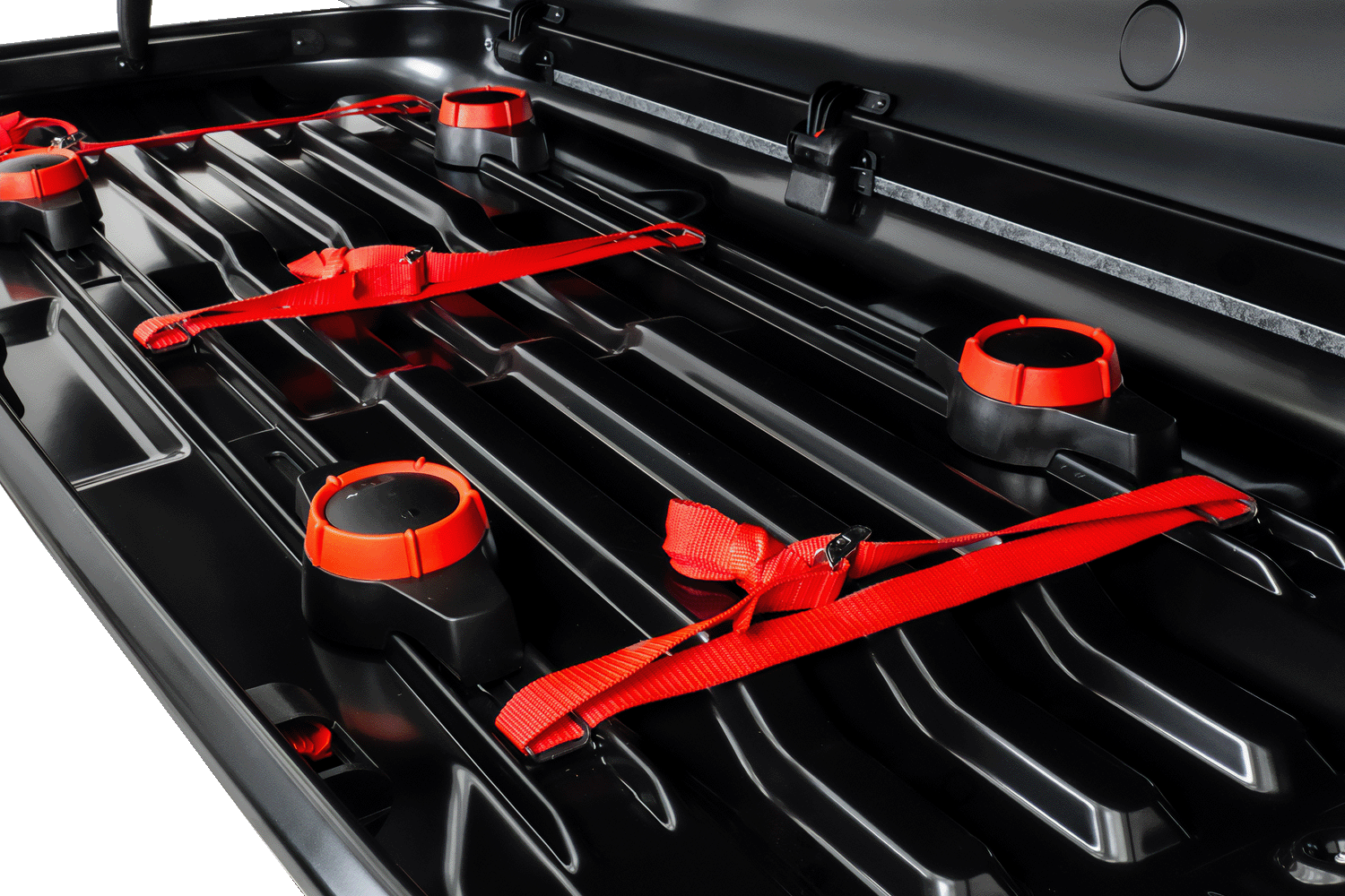 Innenraum der Dachbox. Schwarzer, konturierter Boden, drei rote Textilstreifen verlaufen über den Boden. Vier Knöpfe mit Dynamometer.