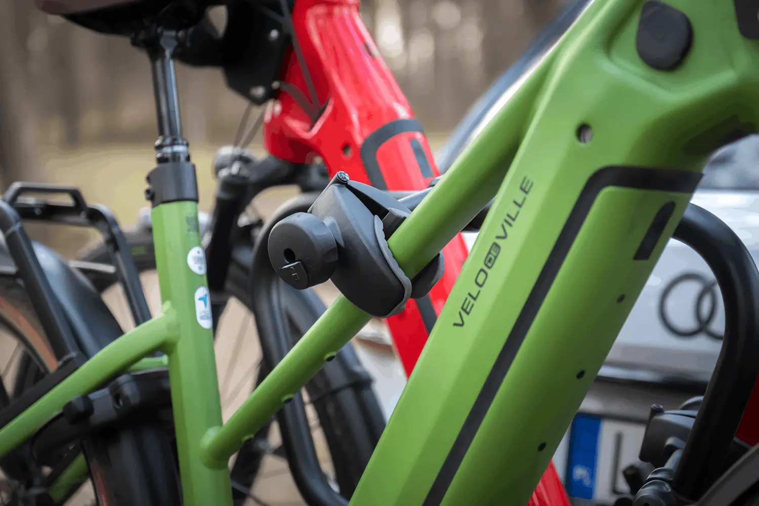 Nahaufnahme der Halteklammer eines Fahrradträgers, die den Rahmen eines grünen E-Bikes fixiert.
