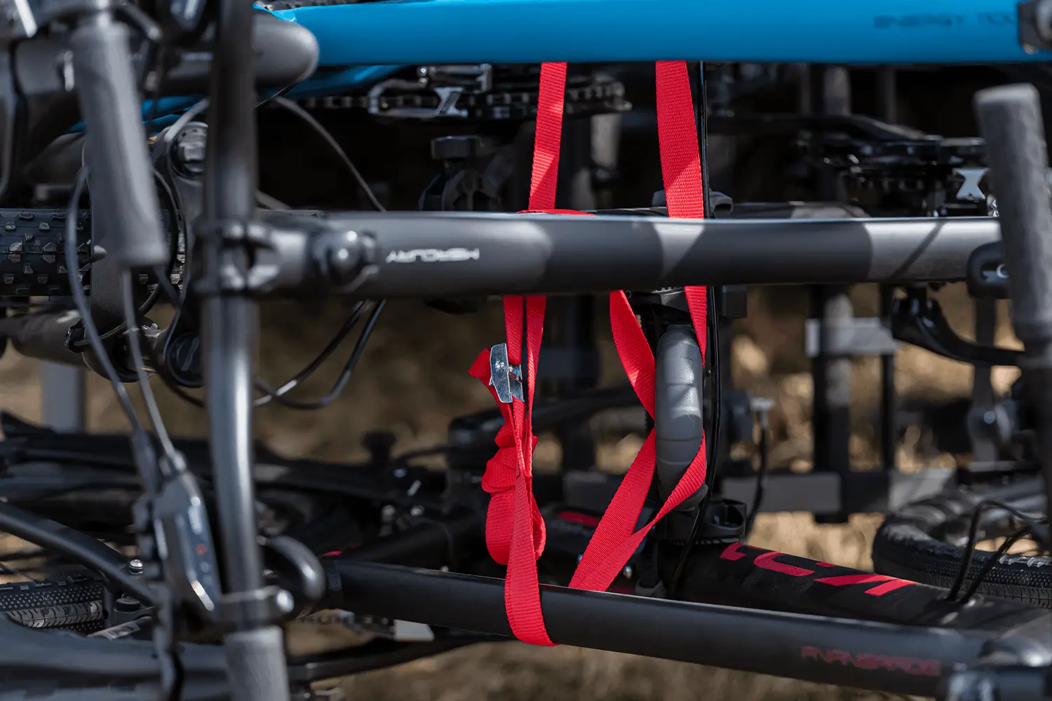 Roter Befestigungsgurt sichert mehrere Fahrradrahmen auf einem Fahrradträger zur Transportsicherung.